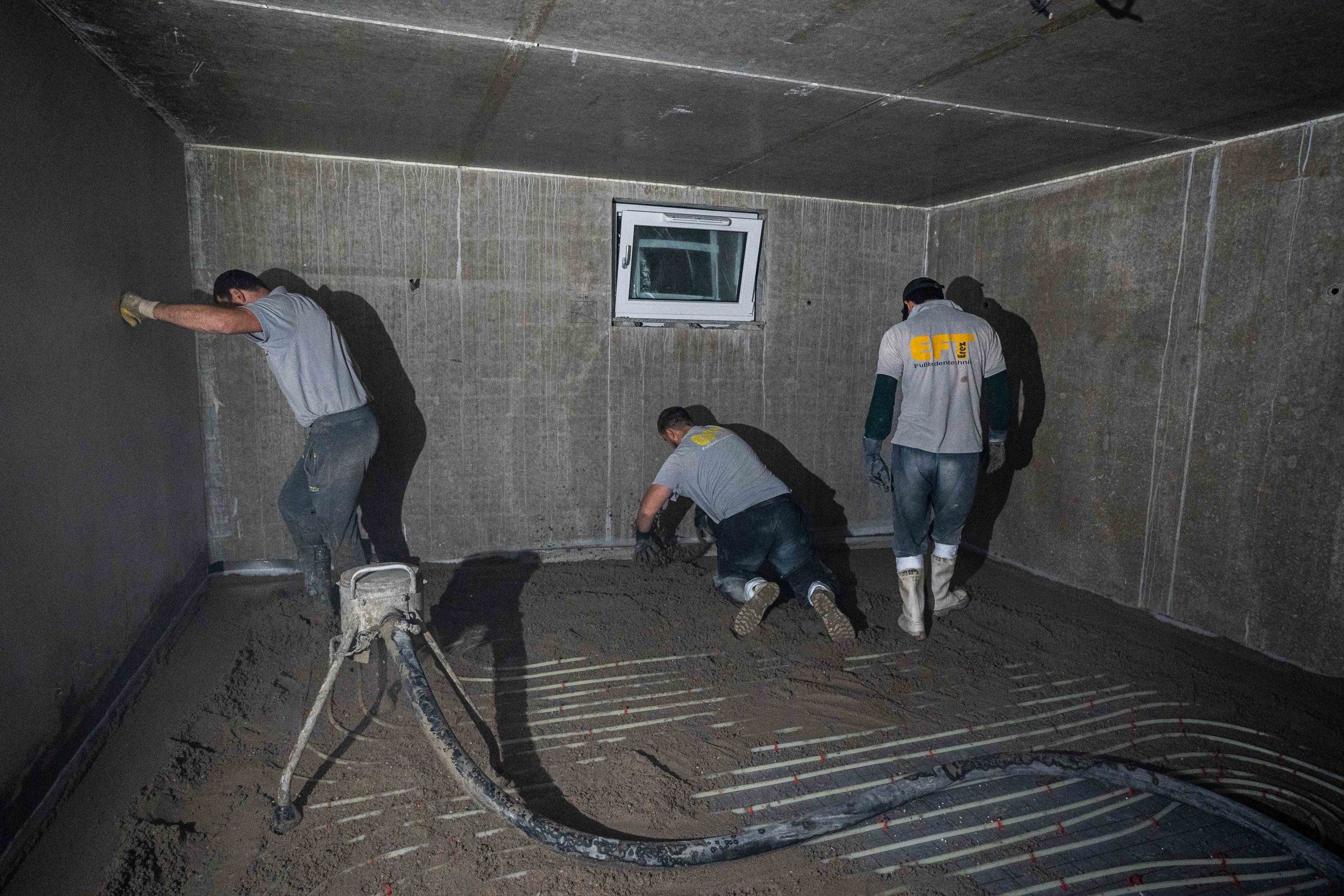 Team von EFT beim Estricheinbau über einer Fußbodenheizung